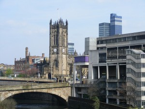 Billede af Manchester katedralen med højhuse i baggrunden og forfaldne bygninger i forgrunden