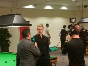 Neil Robertson giver et pre-match interview før sin semifinale mod Judd Trump (som ses med ryggen til i baggrunden)